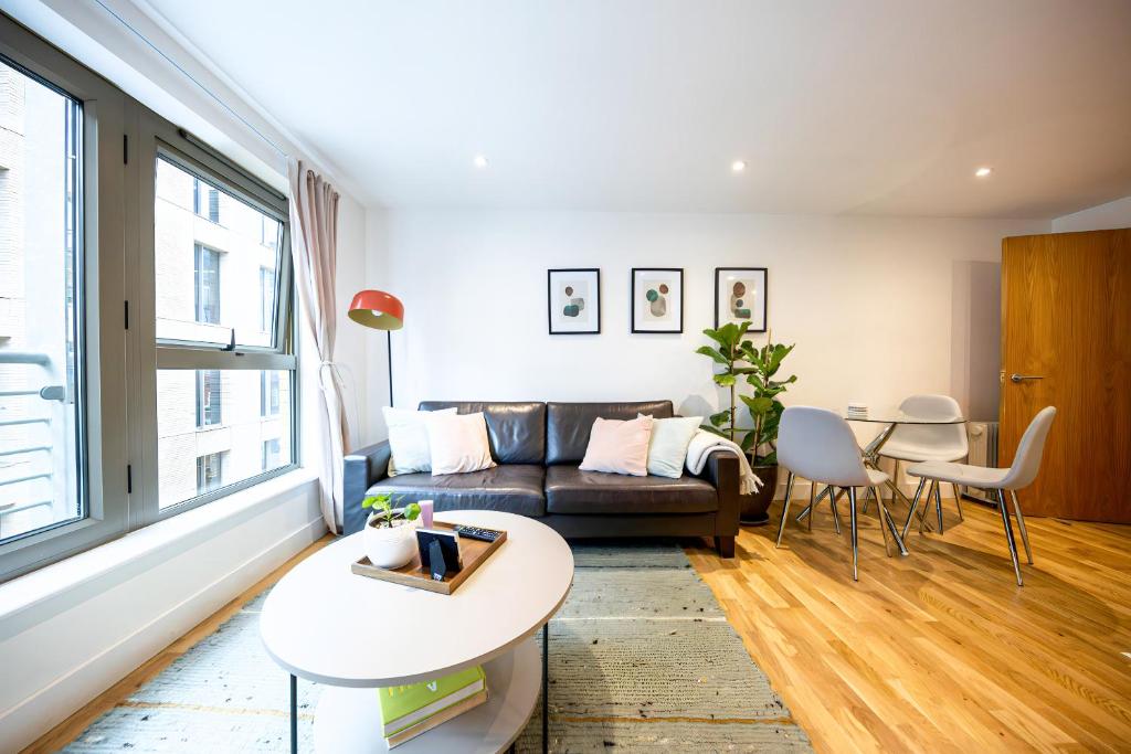 a living room with a couch and a table at Apartment by Spitalfields & Liverpool Street Station in London