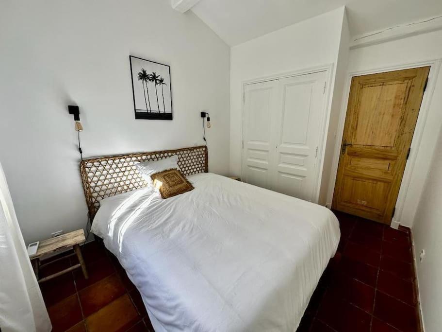 a bedroom with a white bed with a pillow on it at Le Mas Miliane vous accueille in Sainte-Maxime
