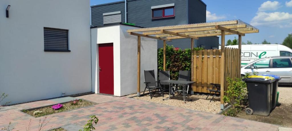 een klein huis met een rode deur en een hek bij Seepark 13a in Goch