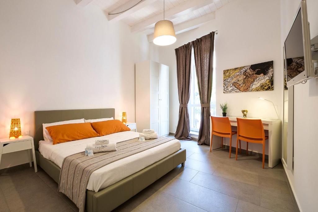 B&B Cala Peppa في باليرمو: غرفة نوم بسرير وطاولة وكراسي