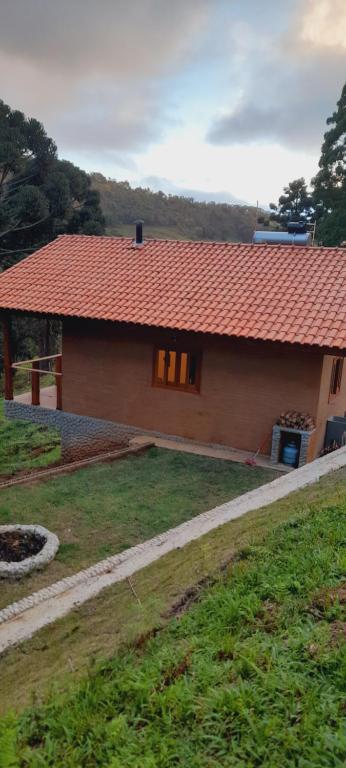 una pequeña casa con techo rojo y patio en Chalé Brisa do Vale, en Santa Luísa de Baixo