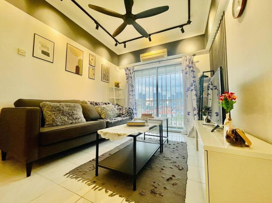 a living room with a couch and a ceiling fan at 8 pax Homestay near Axiata Arena & Pavilion 2 in Kuala Lumpur