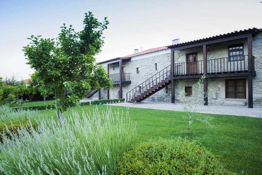 a large building with a balcony and a yard at Casa do Lagar in Mondim da Beira