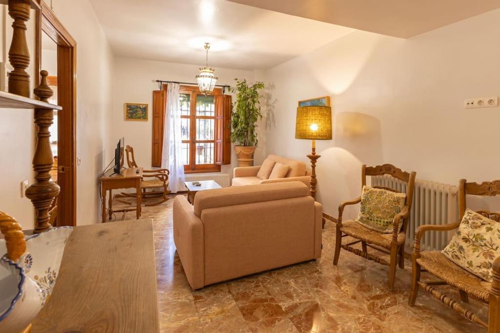 ein Wohnzimmer mit einem Sofa, einem Tisch und Stühlen in der Unterkunft Santa Cruz Refinadores Suite by Valcambre in Sevilla