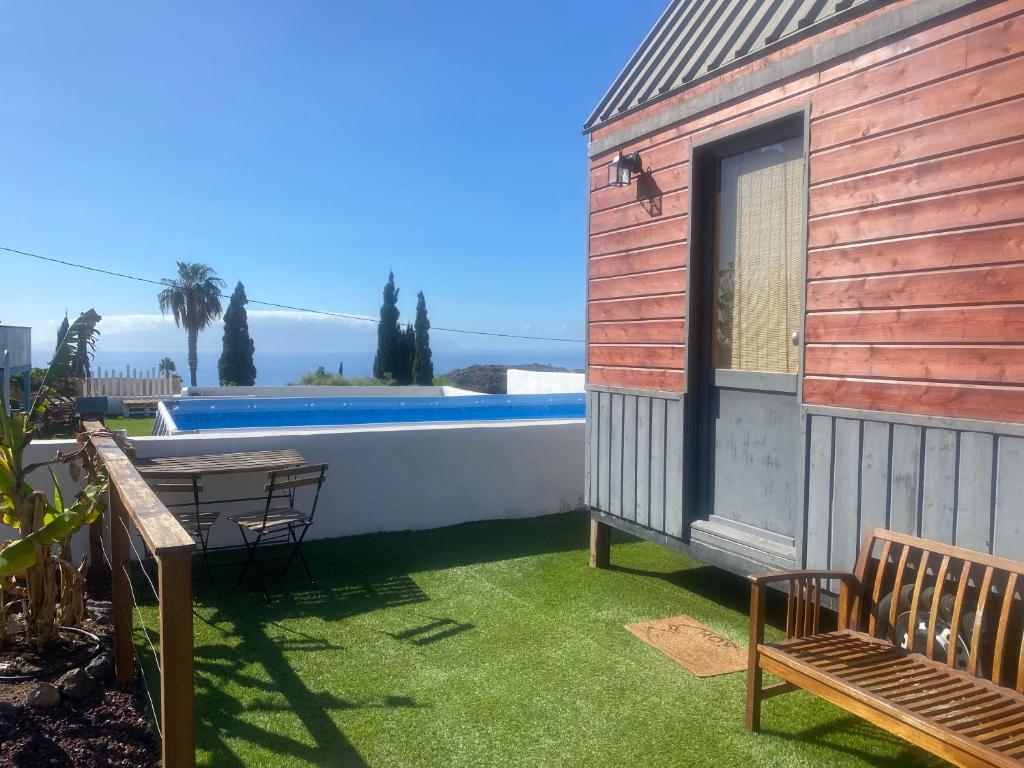 un patio con tavolo, sedie e un edificio di Mini Casa Finca Arcoiris Tenerife a Guía de Isora