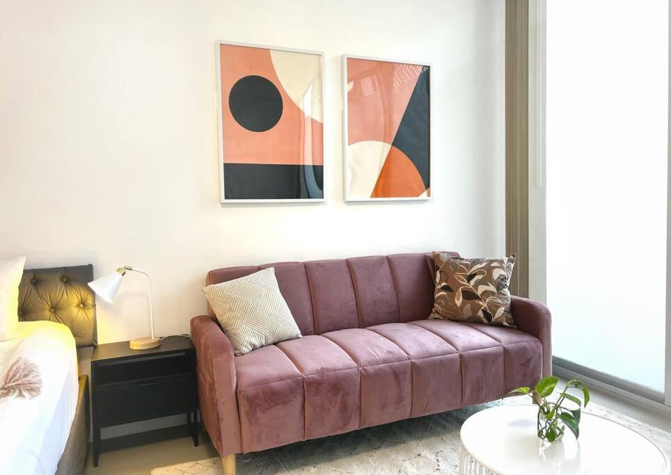 a living room with a couch and a bed at CBD Pink!Studio 1 Bedroom FreeParking in Sydney