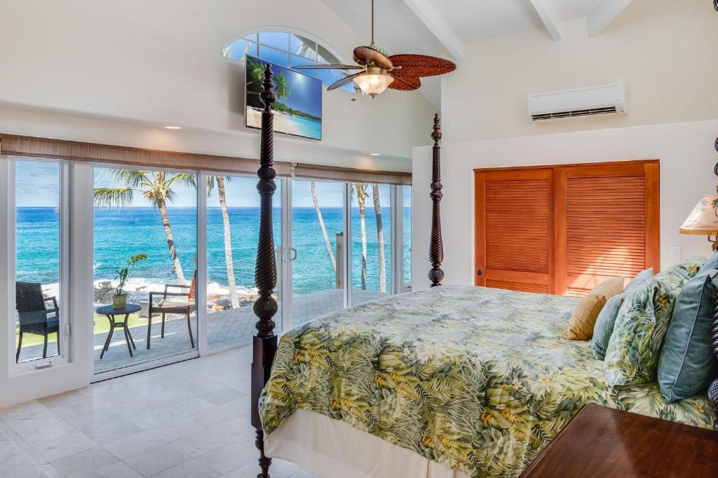 1 dormitorio con cama y vistas al océano en Kona Beach Bungalows, en Kailua-Kona