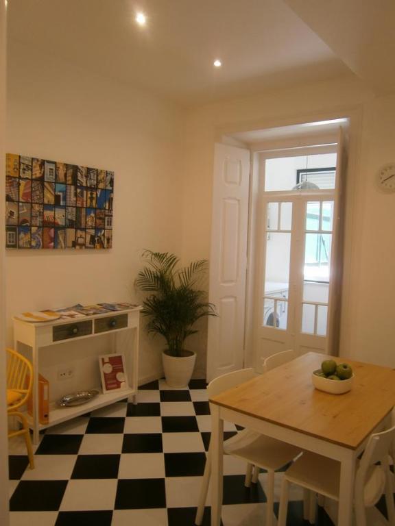 una sala da pranzo con tavolo e pavimento a scacchi di The Estrela Apartment a Lisbona