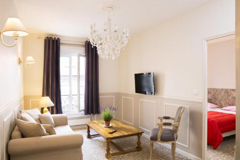 a living room with a couch and a chandelier at Bastille Hostel in Paris