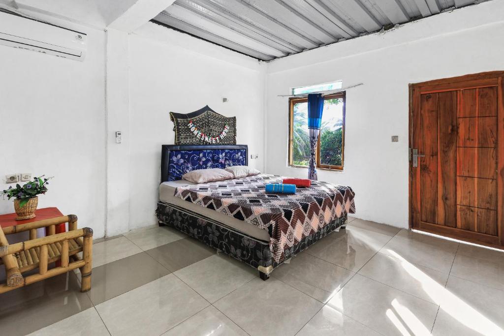 una camera con un letto in una stanza con una finestra di Palulu Garden Homestay a Labuan Bajo