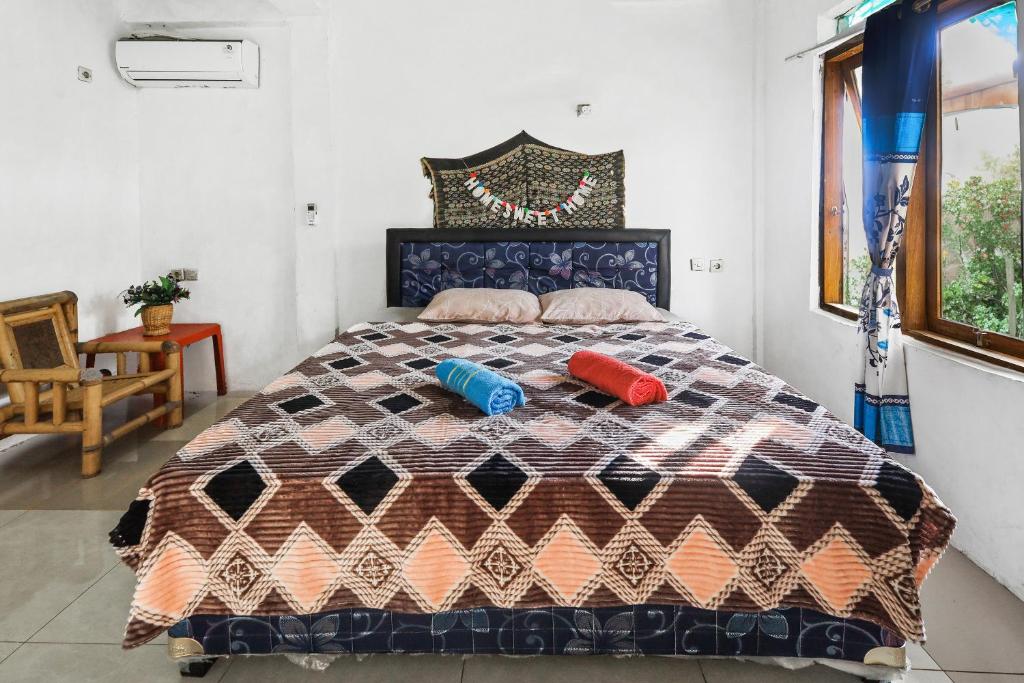 ラブハン・バジョにあるPalulu Garden Homestayの大きなベッドと2つの枕がある寝室