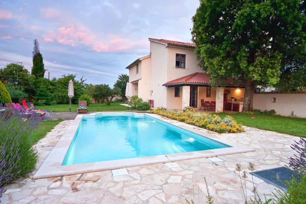 a swimming pool in a yard next to a house at Villa Altra in Krnica