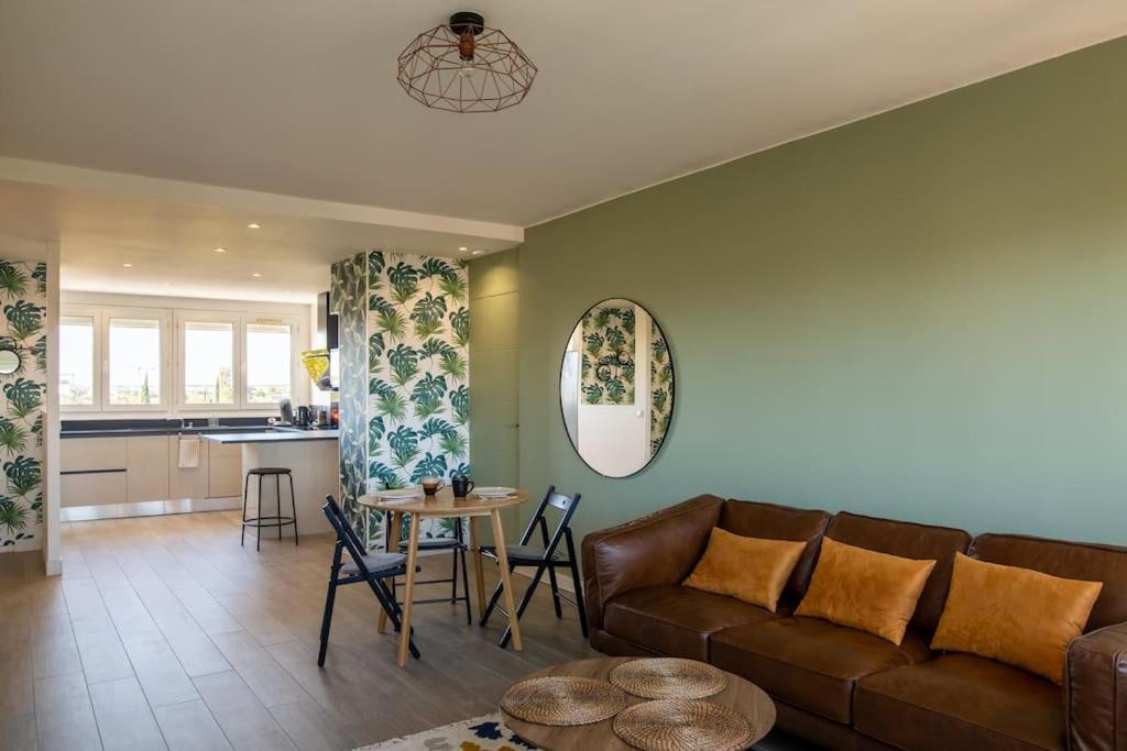 un salon avec un canapé et une table dans l'établissement Le Sauge - Beauzelle, à Beauzelle