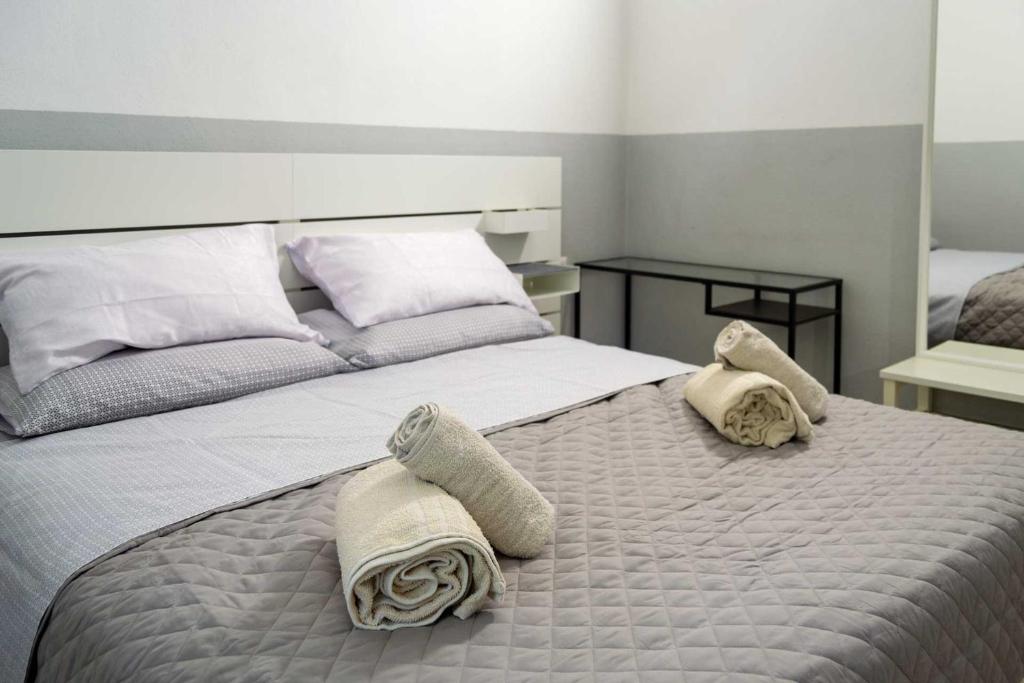 een slaapkamer met een bed met handdoeken erop bij Affittacamere Limin in Busto Arsizio