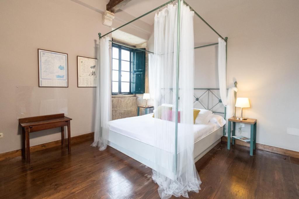 1 dormitorio con cama con dosel y suelo de madera en Rectoral de Cobres 1729, en San Adrián de Cobres