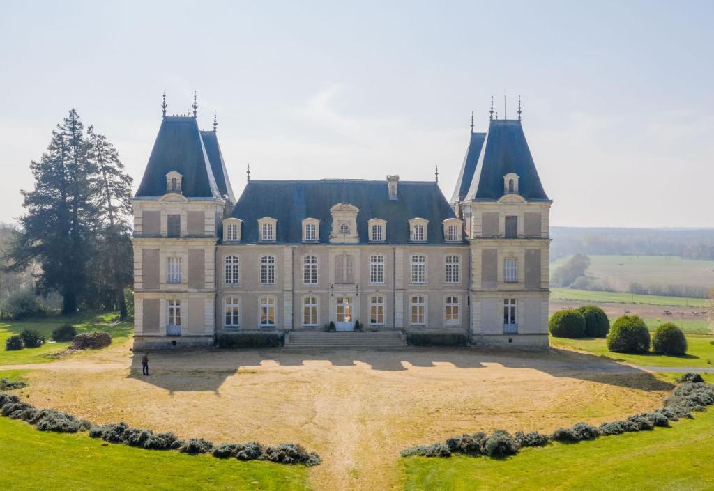 un viejo castillo con un campo de hierba delante de él en Château La Bainerie, en Tiercé
