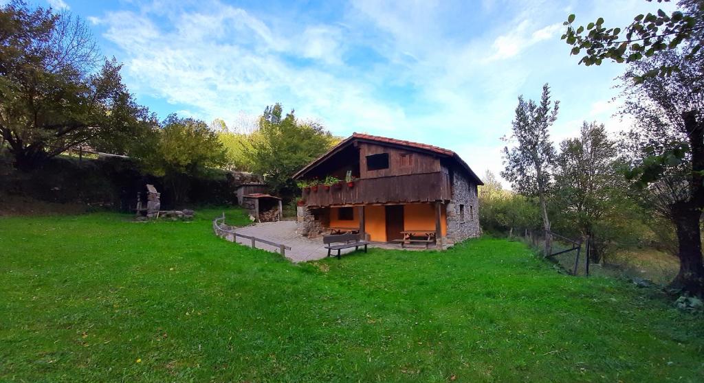 una pequeña casa en un campo con un patio de césped en La Hirririá., en San Roque de Ríomiera
