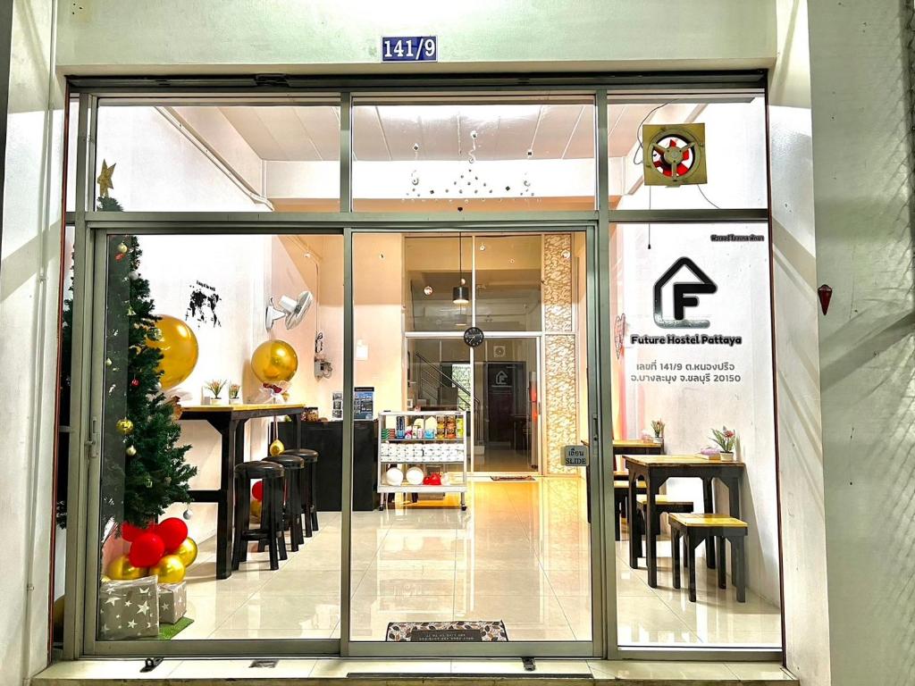 a store front with a christmas tree in the window at Future Hostel Pattaya in Nong Prue