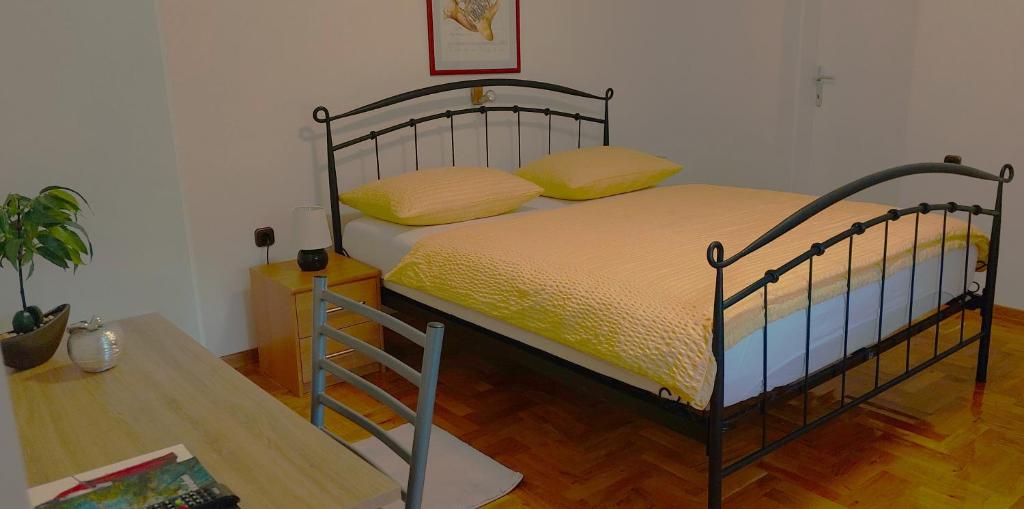 a bedroom with a bed with yellow sheets and a table at EXCELLENT - Kuća za odmor u Županji in Županja