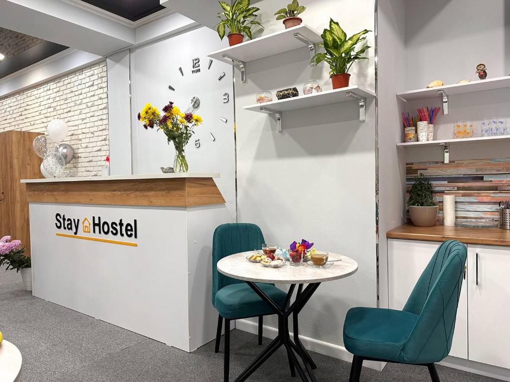 a table and two chairs in a room with a counter at Stay Hostel in Bishkek