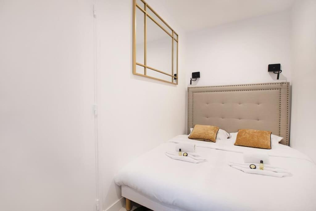 une chambre avec un grand lit blanc avec deux oreillers dans l'établissement Luxury Suite w/ Jacuzzi - Rex / Montorgueil, à Paris