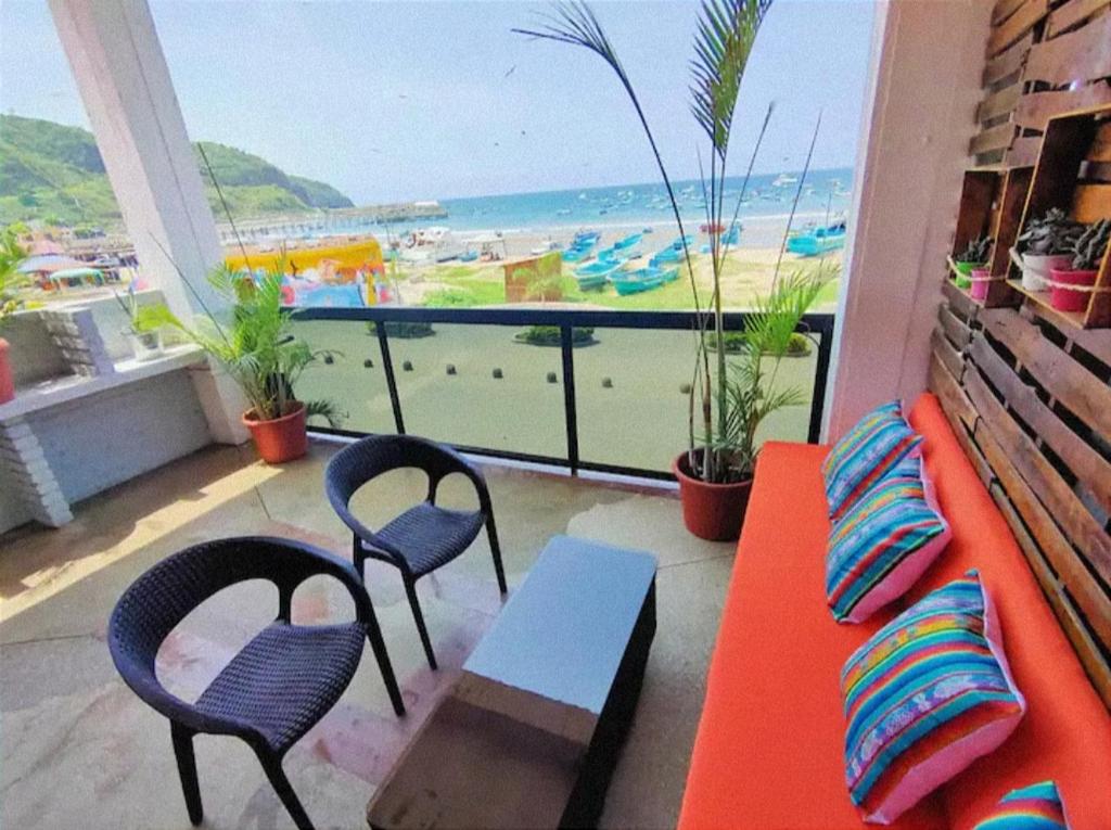 a room with a couch and chairs and a view of the beach at 100m2 Front Beach private apartment in Puerto López
