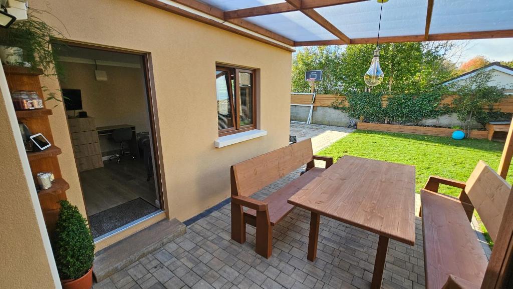 a patio with a wooden table and two benches at Holiday Home in Killarney in Killarney