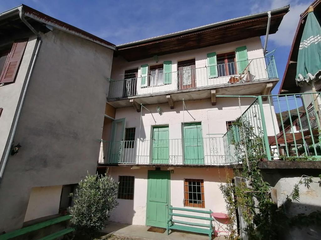 ein Apartmenthaus mit grünen Türen und einem Balkon in der Unterkunft Casa d'arte in the mountains on Lake Orta - 16 per in Quarna Sotto