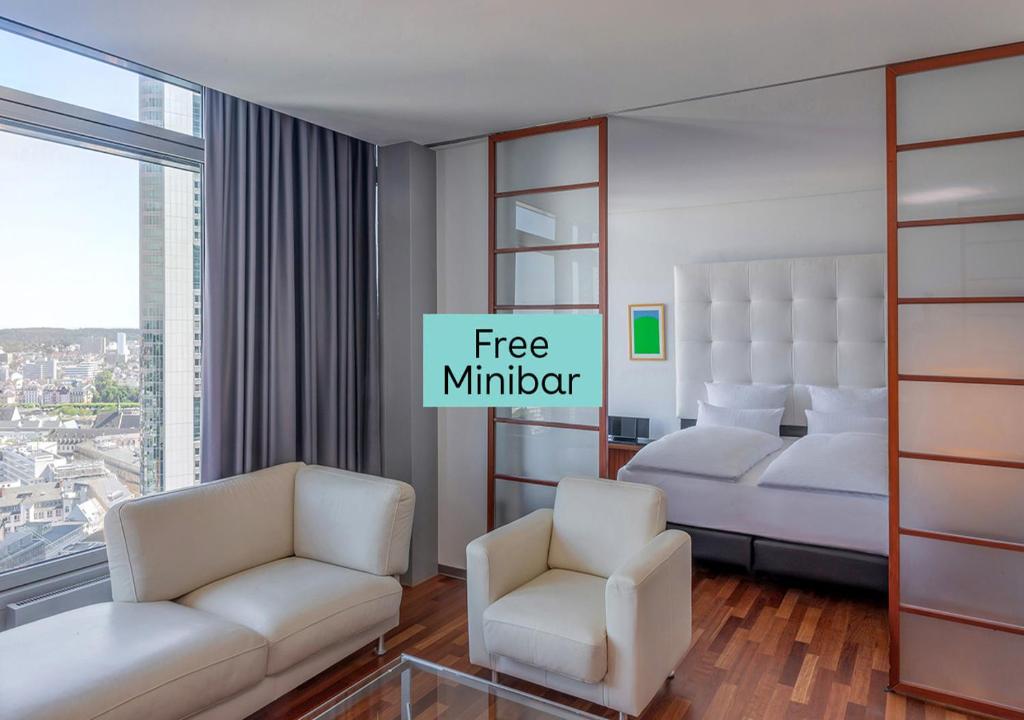 een hotelkamer met 2 bedden en 2 stoelen bij INNSiDE by Meliá Frankfurt Eurotheum in Frankfurt am Main