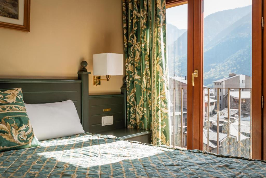 Schlafzimmer mit einem Bett und einem Fenster mit Aussicht in der Unterkunft Hotel Sant Jordi by ALEGRIA in Andorra la Vella