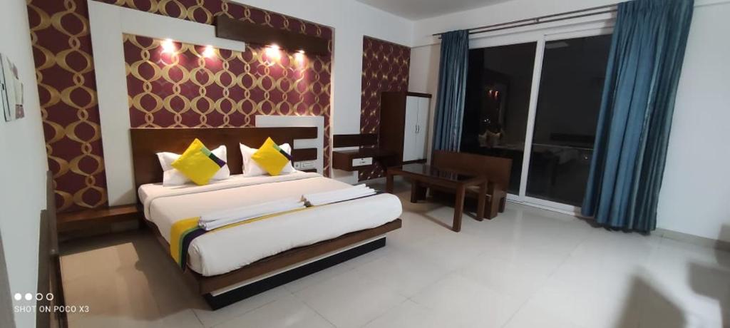 a bedroom with a large bed and a large window at Suite Rooms Bellandhuru in Bangalore