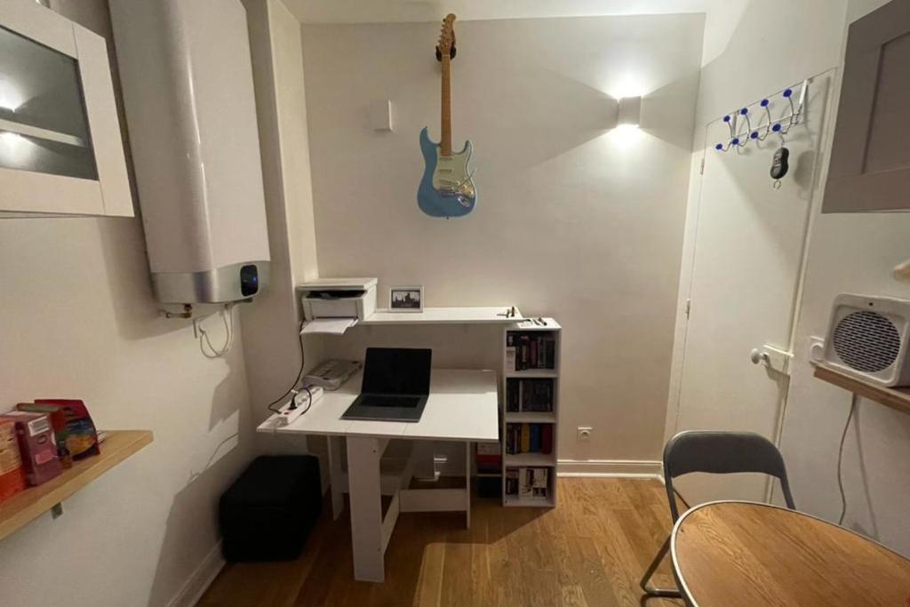 a room with a white desk with a laptop on it at Lovely love nest near Paris in Clichy