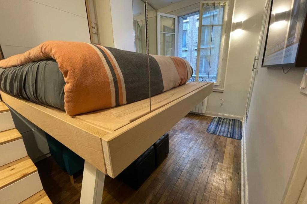 a couch sitting on top of a bed in a room at Lovely love nest near Paris in Clichy