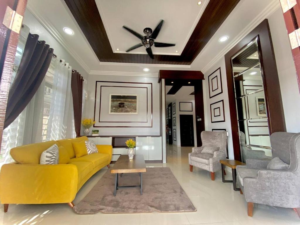 Wakaf BaharuにあるHomestay Wakaf Bharu Tumpatのリビングルーム(黄色のソファ、椅子2脚付)