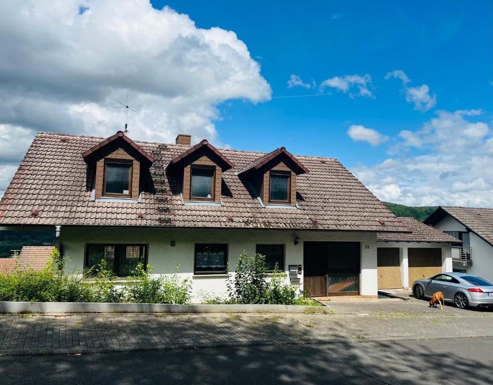 a house with a roof with a car parked in front at Weitblick 1 in Amorbach