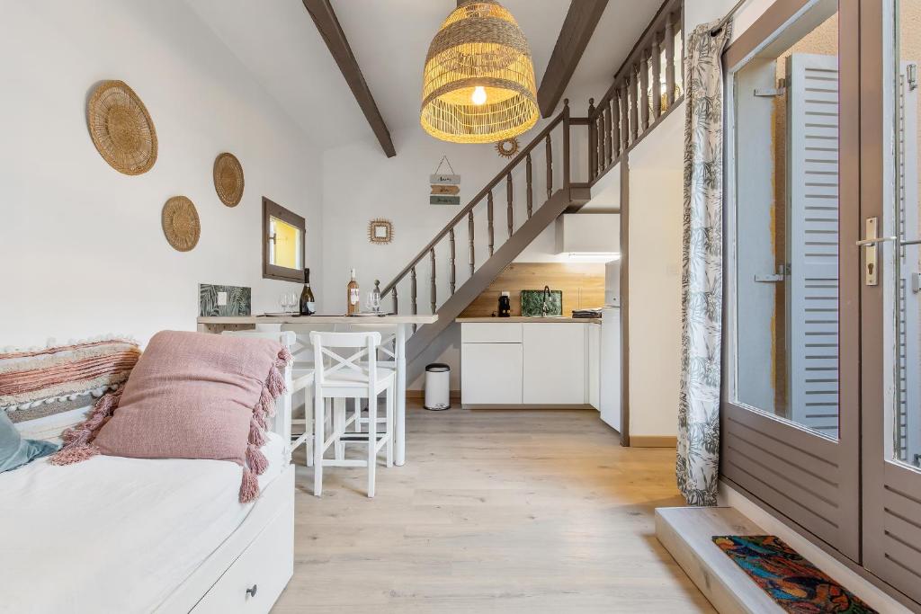 een kamer met een trap en een woonkamer met een tafel bij L'Effet Mer in Cap d'Agde