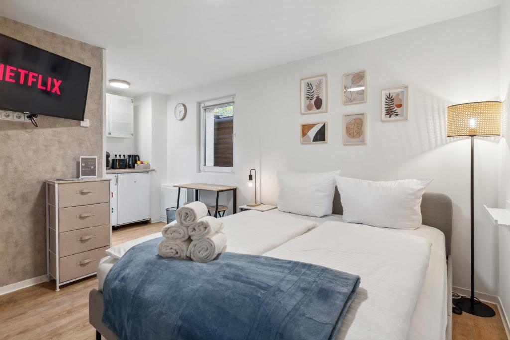 una camera con un grande letto bianco e una TV di Vorstadtoase - Apartment für 2 Personen mit Smart TV, Parken, eigenen Bad, Netflix - Nähe BER a Eichwalde