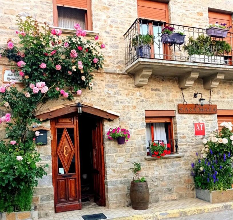 a building with flowers on the side of it at Casa Maza Apartamentos in Biescas