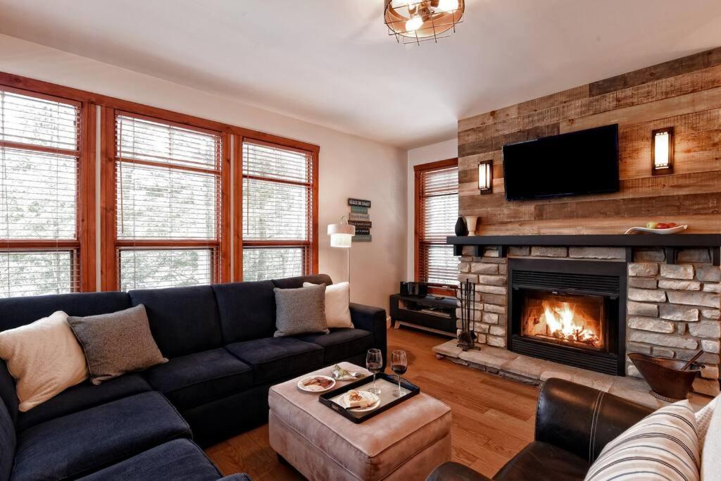 a living room with a couch and a fireplace at Tremblant Les Eaux A - Mont-Tremblant in Mont-Tremblant