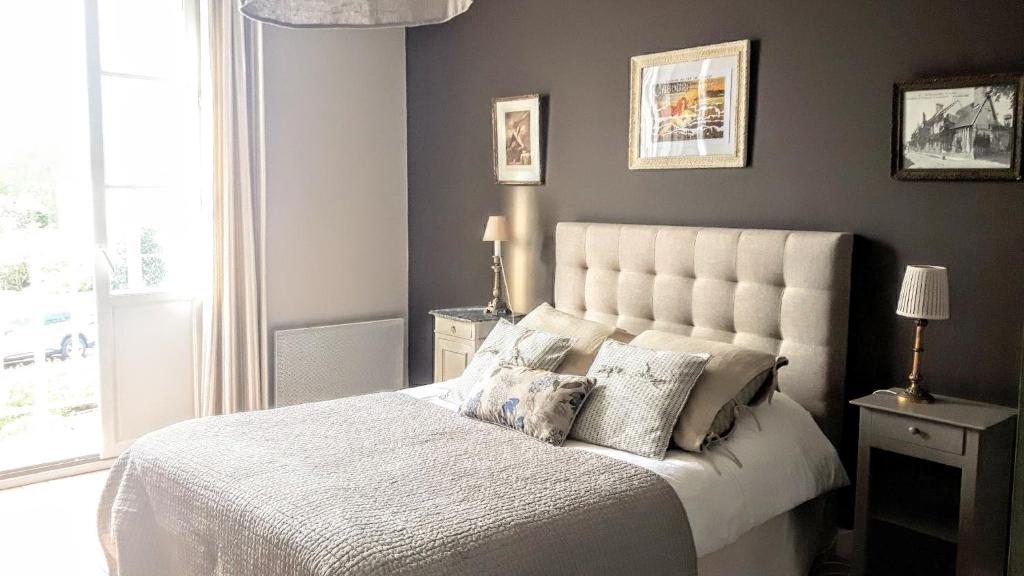 una camera da letto con un grande letto bianco con due cuscini di Le Cottage de la Plage - 2ch, 2 SDB - Terrasse - Déco de charme - 500m plage a Cabourg