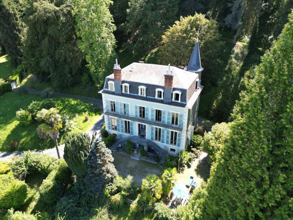 Villa Morton - Domaine du Grand Tourmalet Pic du Midi في بانيير-دوبيغور: اطلاله هوائيه على بيت ابيض كبير مع برج