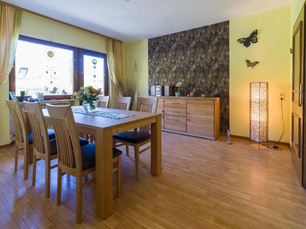 una sala da pranzo con tavolo e sedie in legno di Ferienwohnung Haus Nahetal a Gonnesweiler