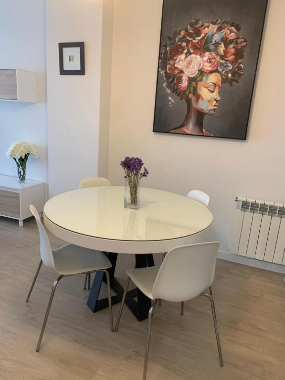 uma sala de jantar com uma mesa branca e cadeiras em Acogedor apartamento en Baiona em Baiona