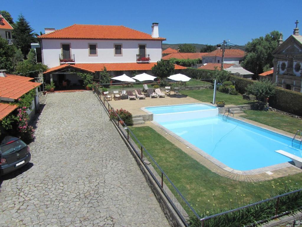 a large swimming pool in front of a house at Casa Paz do Outeiro in Paredes de Coura