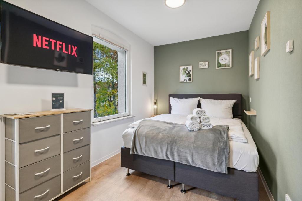 a bedroom with a bed and a tv on the wall at Vorstadtoase - 3 Personen - Apartment mit Queensize-Bett, Badewanne, Schlafcouch, Parken, Netflix, Nähe BER in Eichwalde