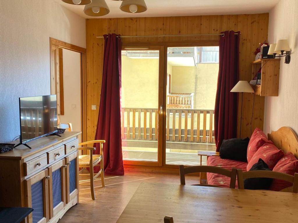 d'un salon avec une télévision et une porte coulissante en verre. dans l'établissement Appartement 2 pièces cabine, 6 personnes, piscine, parking, WiFi - FR-1-636-13, à Orcières