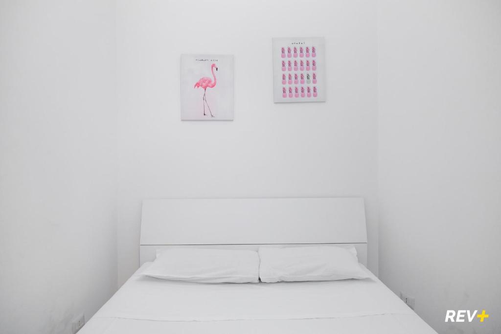a bed in a room with a pink flamingo on the wall at Piazza Bologna Holiday House in Rome