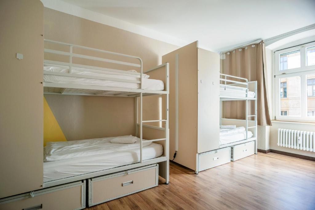 a room with two bunk beds and a window at EastSeven Berlin Hostel in Berlin