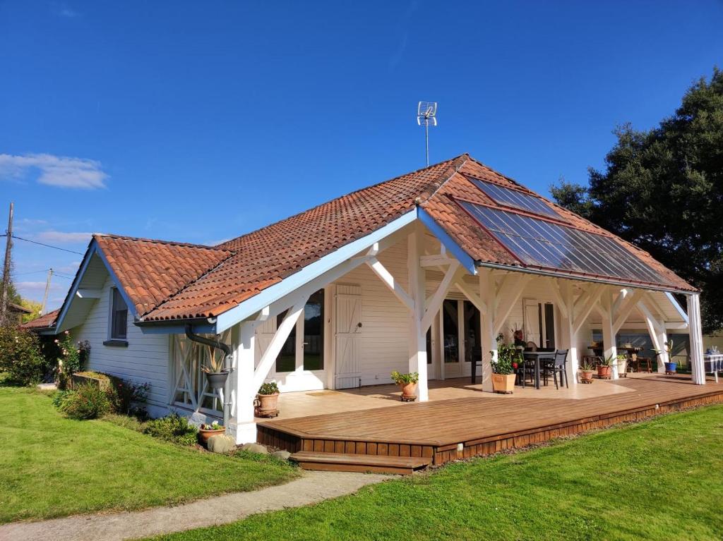 una casa con terraza de madera en el patio en Louisiane, en Onard