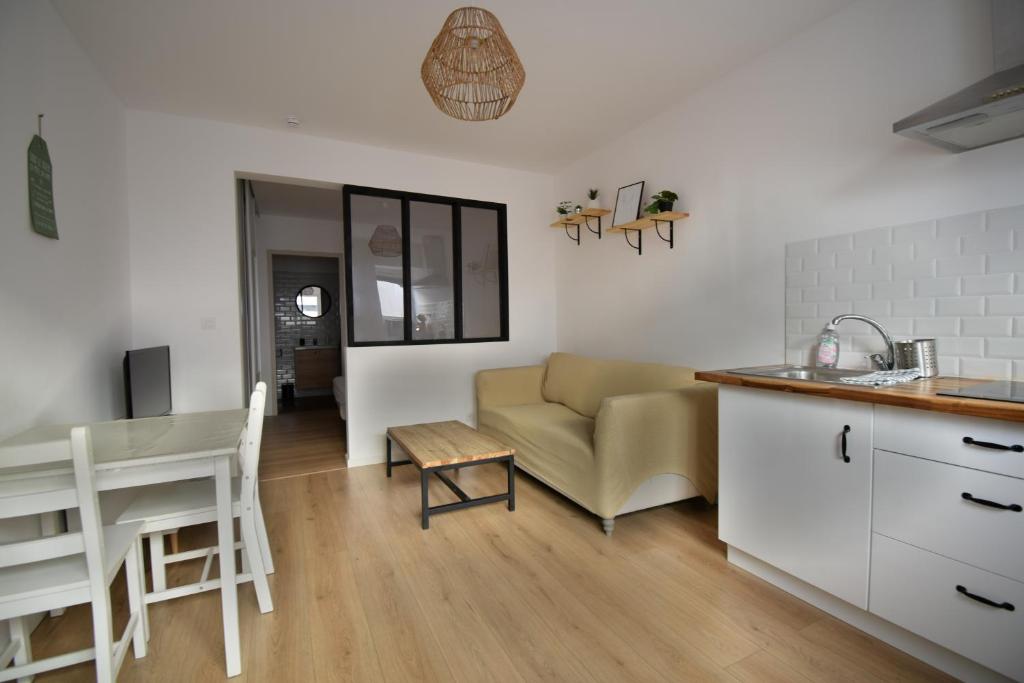 una cucina e un soggiorno con un divano e un tavolo di Appartement cosy à 50 m de la plage et du port a Mèze